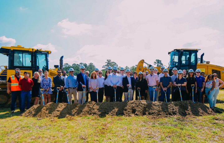 Team holding shovels at site