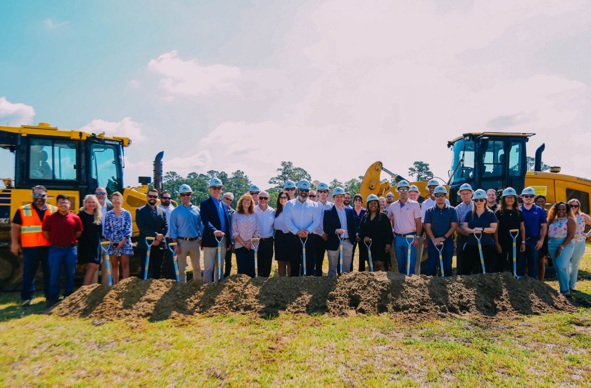 Team holding shovels at site